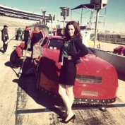 Annie Wersching poses next to racecar on Dallas set